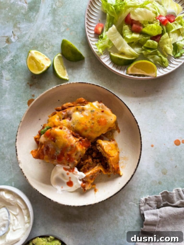 Comforting Slow Cooker Smothered Burritos 2 Super Cheesy Smothered Burritos in a slow cooker, ready to serve.