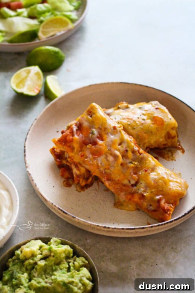 Comforting Slow Cooker Smothered Burritos 4 Slow Cooker Smothered Burritos in a bowl with a fork, ready to eat.