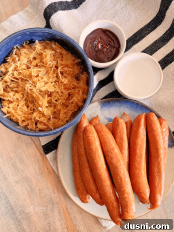 BBQ Hot Dogs and Sauerkraut 5 Baked hot dogs topped with BBQ sauerkraut in a Dutch oven, ready to be served.