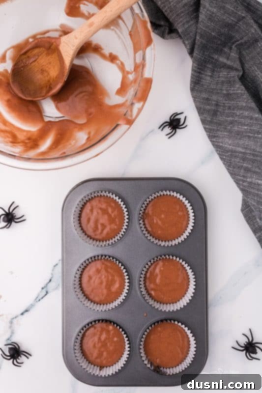 Ghoulish Grey Matter Cupcakes 11 A visual step-by-step image showing the wet and dry ingredients for the Halloween Brain Cupcakes being mixed in a bowl, illustrating the batter preparation.
