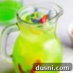 Jug full of Halloween kids punch topped with gummy worms