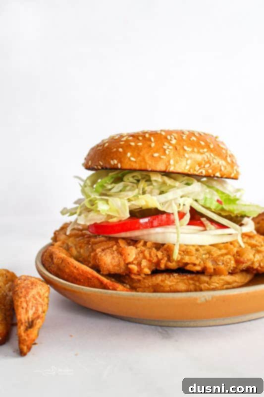 Tenderloin Crunchwich 2 A perfectly prepared Breaded Pork Tenderloin Sandwich, showcasing its generous size and crispy texture.
