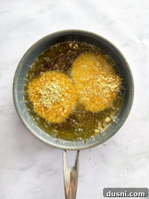 Tenderloin Crunchwich 11 A breaded pork cutlet, fully coated and ready for frying.