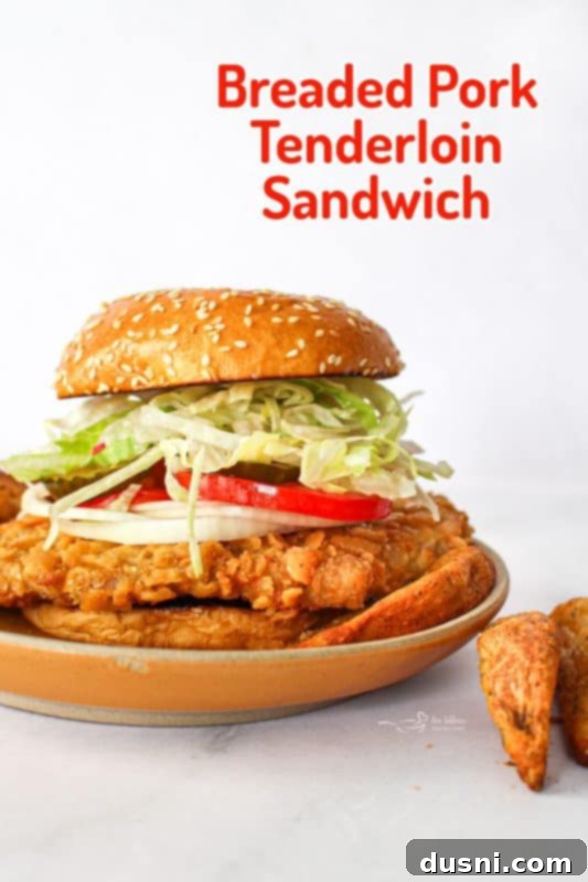 Tenderloin Crunchwich 18 A stunning hero shot of a Breaded Pork Tenderloin Sandwich, highlighting its golden crust and fresh ingredients.