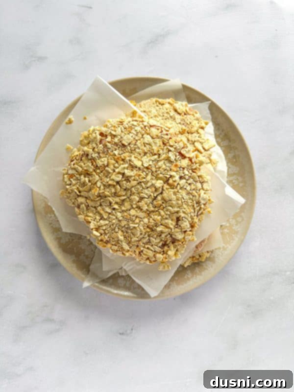 Tenderloin Crunchwich 10 A pork chop being coated in egg wash, the second step in the breading process.