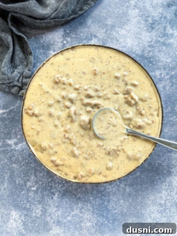 A rustic cutting board with freshly baked, golden-brown biscuits, ready to be split and topped with gravy.
