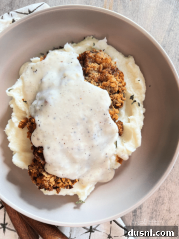 A plate of crispy Air Fryer Chicken Fried Steak covered in creamy white gravy, a hearty comfort meal.