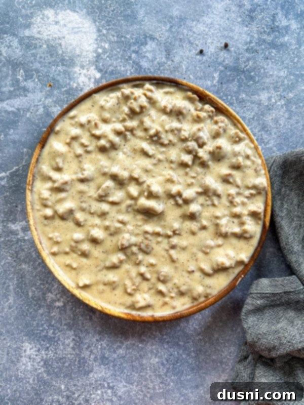 Close-up of a hearty portion of homemade sausage gravy, ready to be ladled over biscuits.