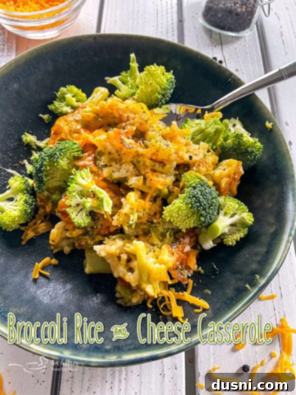 Front view of broccoli and cheese casserole on dark plate with spoon
