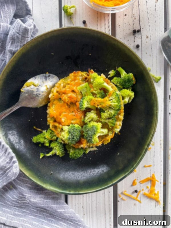 Cheesy Broccoli Rice Comfort Bake 9 One serving of broccoli and cheese casserole on dark plate