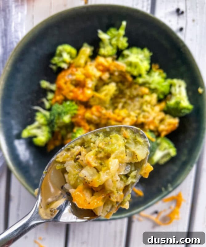 Close up view of broccoli and cheese casserole in a spoon