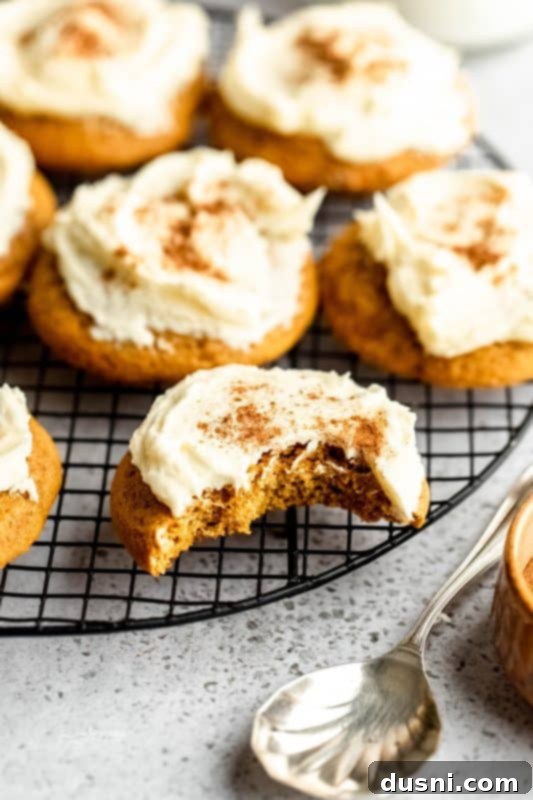 Close-up of a soft pumpkin cookie with vanilla frosting