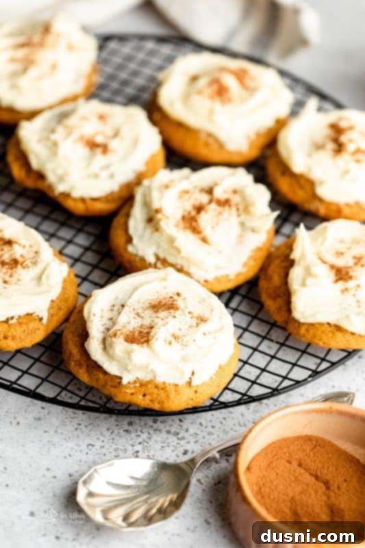 Frosted pumpkin cookies on a marble surface