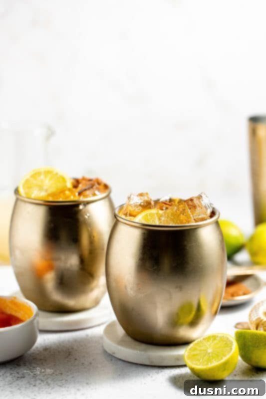 Pumpkin Spice Moscow Mule served in a copper mug with cinnamon sticks and a lime slice