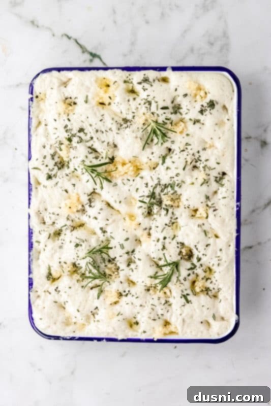 Step 7: Focaccia bread topped with garlic and rosemary before baking