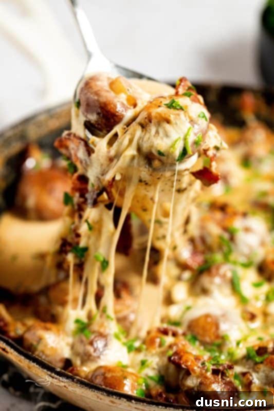 Velvety Bacon Mushroom Skillet 2 Close-up of a skillet filled with golden brown creamy mushrooms and bacon, garnished with fresh herbs