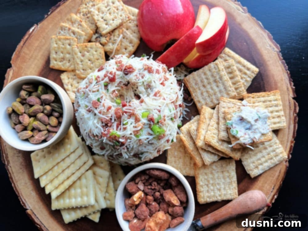 The Sauerkraut Bacon & Swiss Cheese Ball on a serving board with a variety of crackers, emphasizing its readiness for a party.
