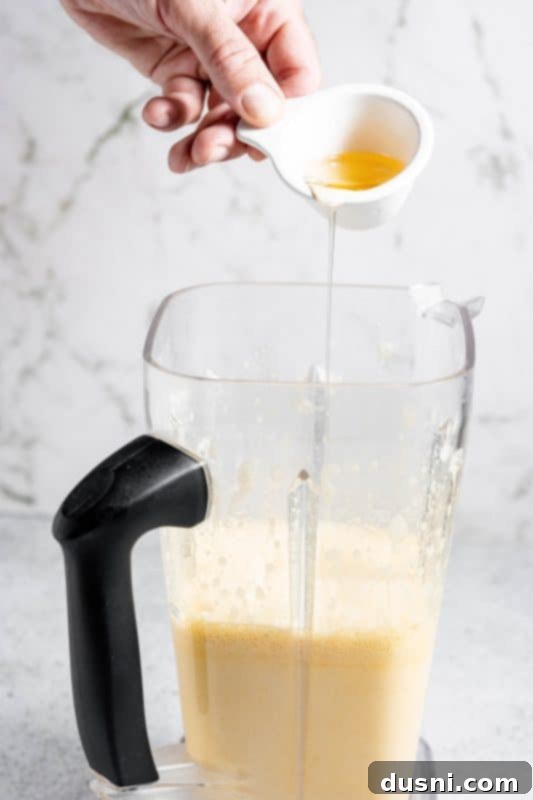 Homemade Blender Eggnog 11 Adding bourbon and rum to the blender for a classic boozy eggnog.