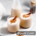 Homemade Blender Eggnog 21 Two glasses of eggnog topped with a cinnamon stick.