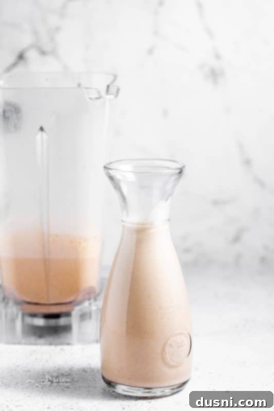 Homemade Blender Eggnog 5 Pouring homemade eggnog into a glass, highlighting its rich, creamy texture.