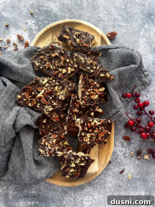 Classic Handcrafted Toffee 3 Toffee pieces arranged on a gray napkin, coated in chocolate and nuts.