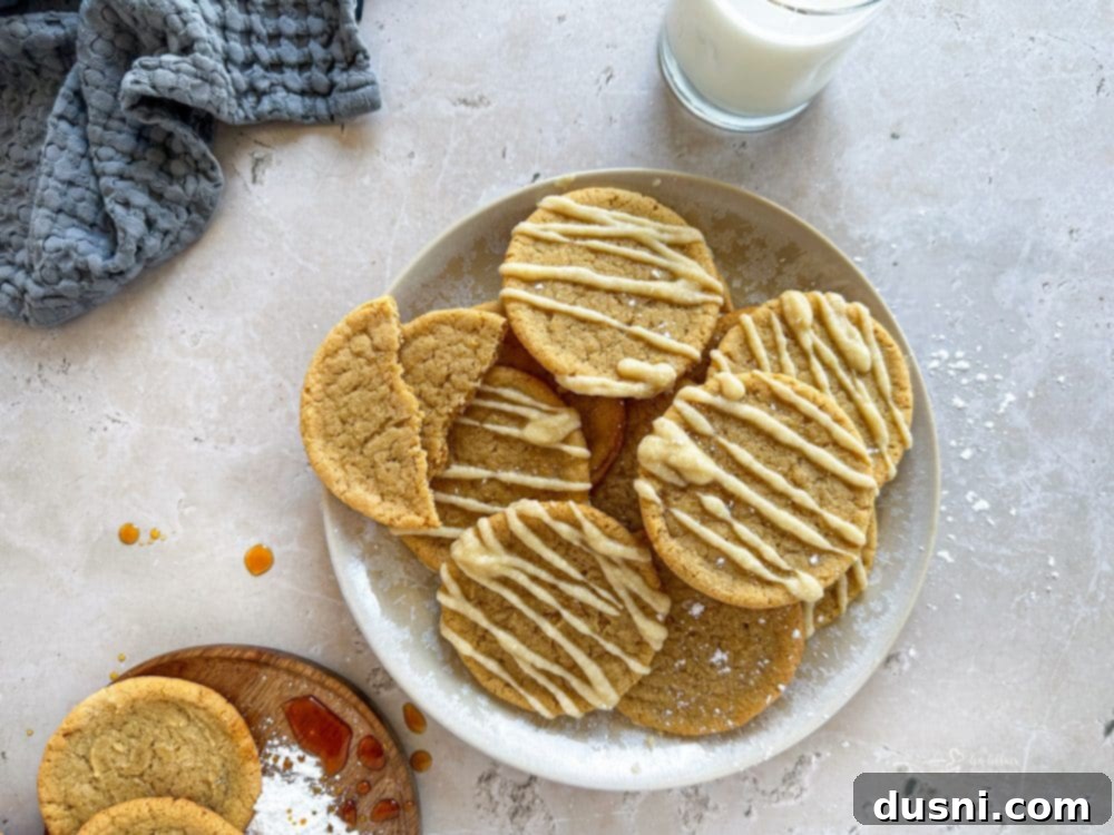Iced Maple Sugar Cookies arranged on a marble surface with fall decor