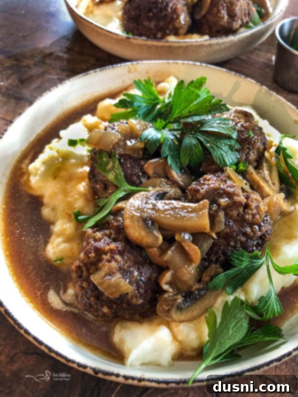 The 10 Best Recipes of 2023 9 Close-up of Salisbury Steak Meatballs served over mashed potatoes with a rich gravy and mushrooms