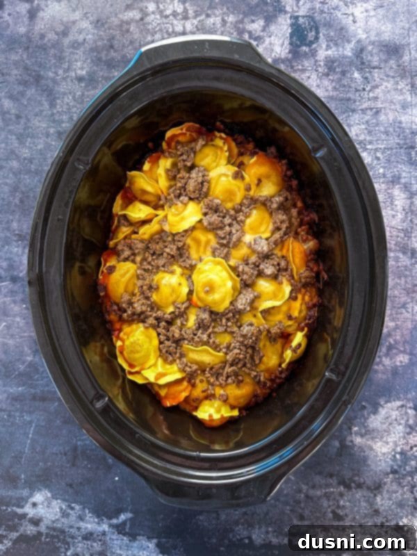 Lazy Slow Cooker Ravioli Lasagna 11 Easy Crockpot Lasagna cooking in a slow cooker.