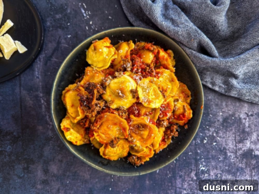 Lazy Slow Cooker Ravioli Lasagna 3 Close-up of a serving of Slow Cooker Ravioli Lasagna, showing melted cheese and rich sauce.