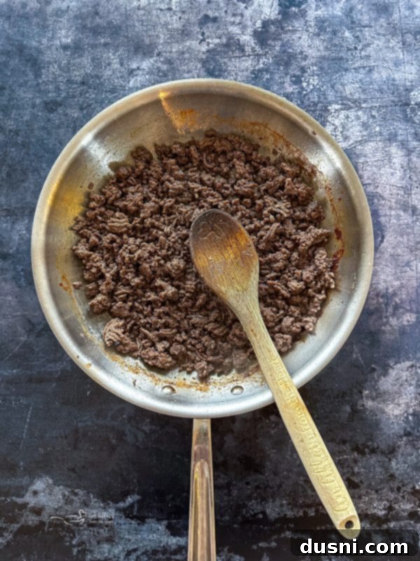 Lazy Slow Cooker Ravioli Lasagna 7 Step 1: Browning ground beef with Italian seasoning in a skillet.