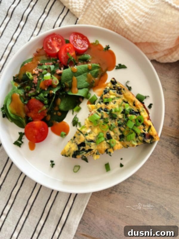 Dorothy's Hearty Bacon & Potato Frittata 2 A slice of Bacon and Potato Frittata and a fresh green side salad on a white plate