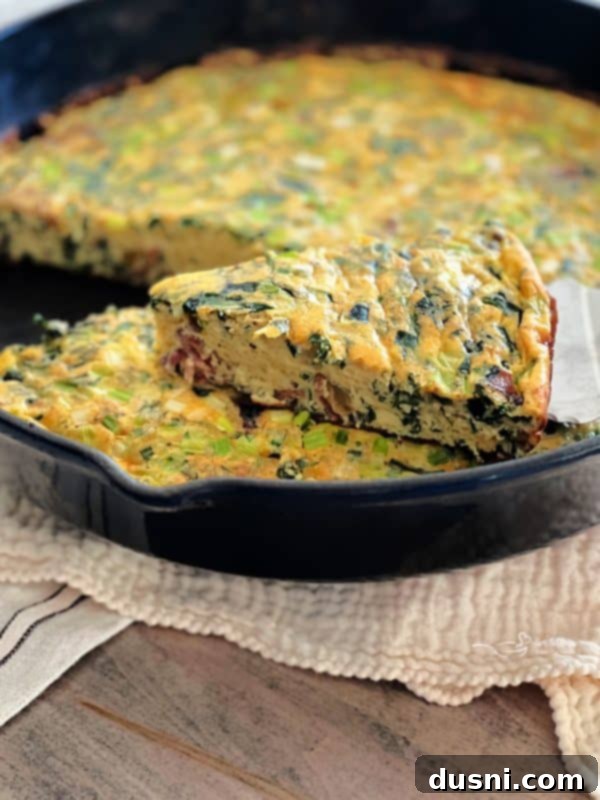 Dorothy's Hearty Bacon & Potato Frittata 14 A slice of Bacon and Potato Frittata on a plate with fresh herbs