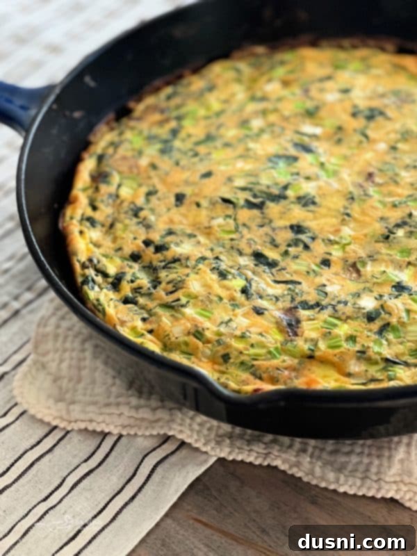 Dorothy's Hearty Bacon & Potato Frittata 4 A large cast iron skillet filled with Dorothy's Bacon and Potato Frittata, garnished with fresh herbs
