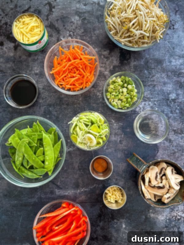 Savory Beef Lo Mein 6 Ingredients laid out on a cutting board, including beef, vegetables like carrots, bell peppers, and mushrooms, ready for preparation.
