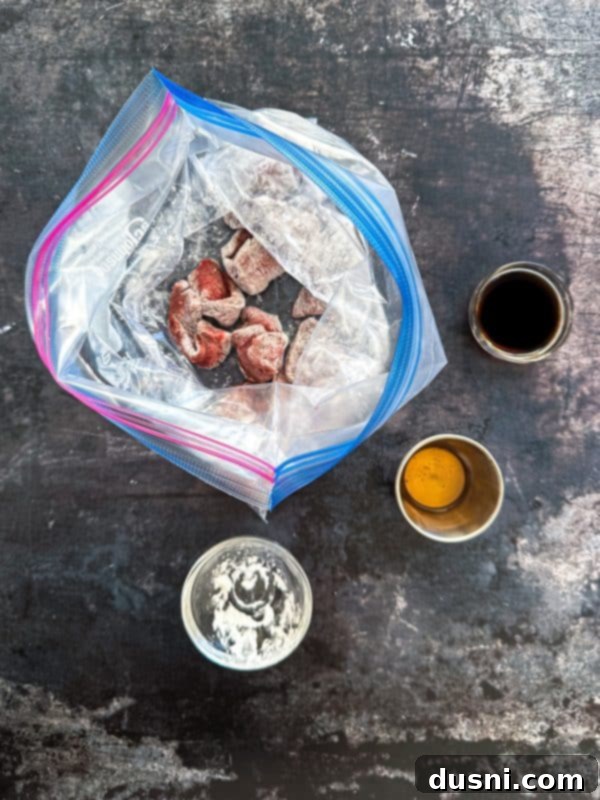 Savory Beef Lo Mein 7 Image showing thinly sliced beef strips being tossed with cornstarch and soy sauce in a zip-top bag for marination.