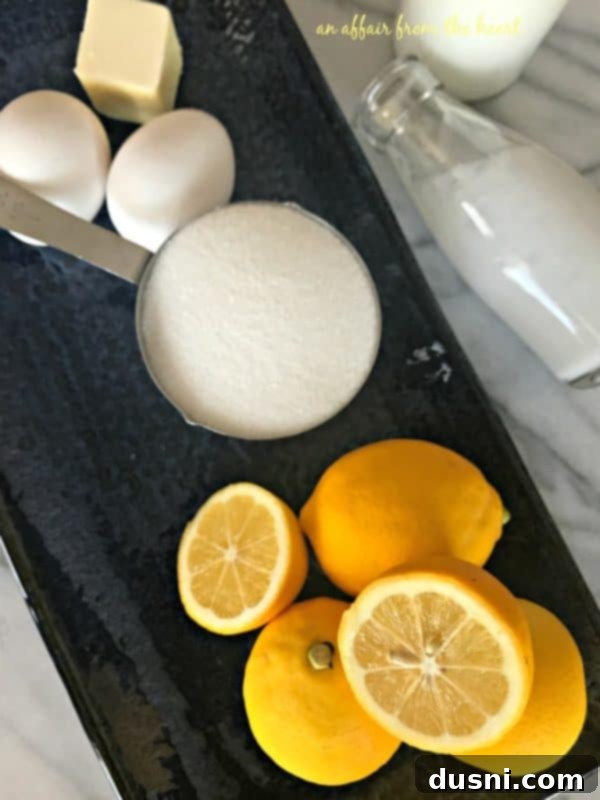 Zesty Lemon Indulgence 5 Ingredients for lemon ice cream laid out: fresh lemons, eggs, butter, sugar, and heavy cream.