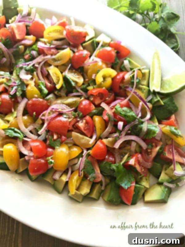 Side view of the Deconstructed Guacamole Salad, showing colorful layers of tomatoes, avocado chunks, and red onion.