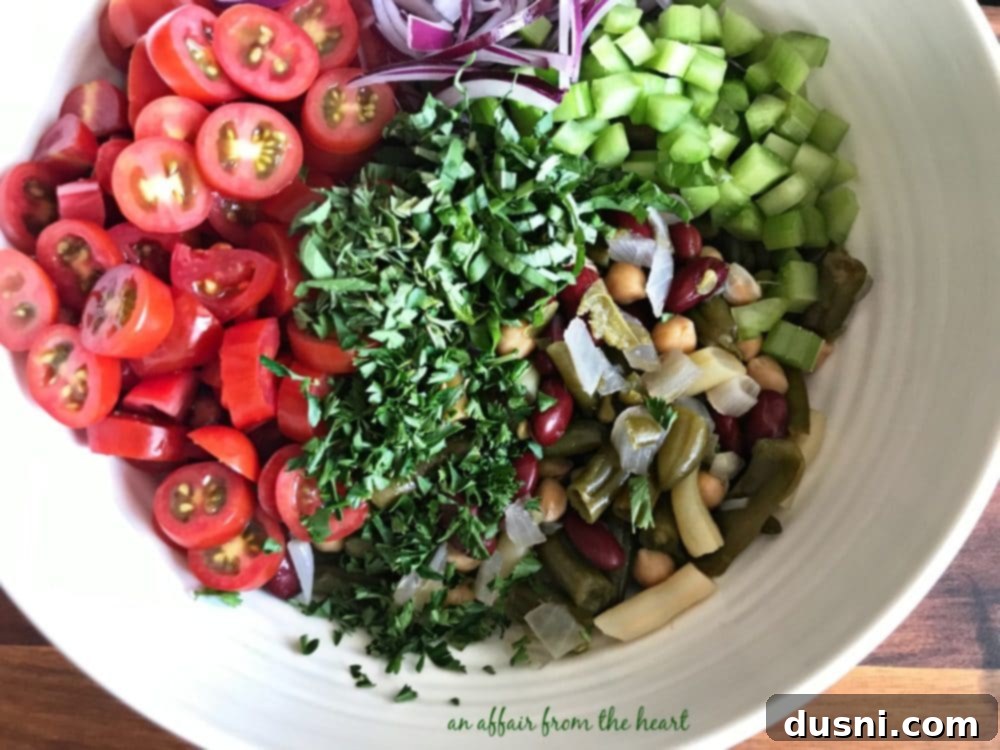 Vibrant Italian Bean Salad 7 Hand tossing Italian Bean Salad ingredients in a white bowl