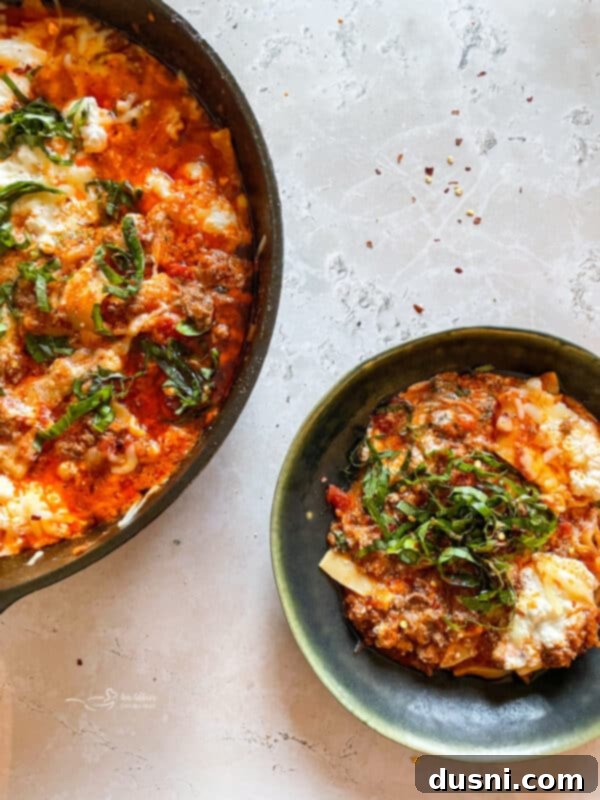 Close-up of skillet lasagna being served into a bowl