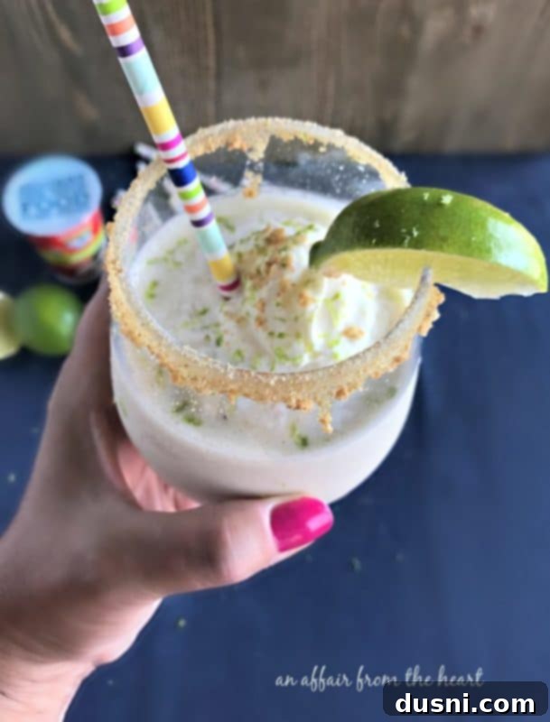 Zesty Key Lime Delight 3 Close-up of a Key Lime Pie Smoothie with lime slices and whipped cream.