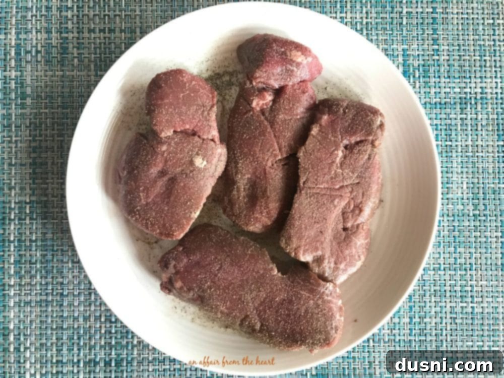Gourmet Herb Butter Filet Mignon 4 Seasoned Filet Mignon steaks, ready for searing in a cast iron skillet.