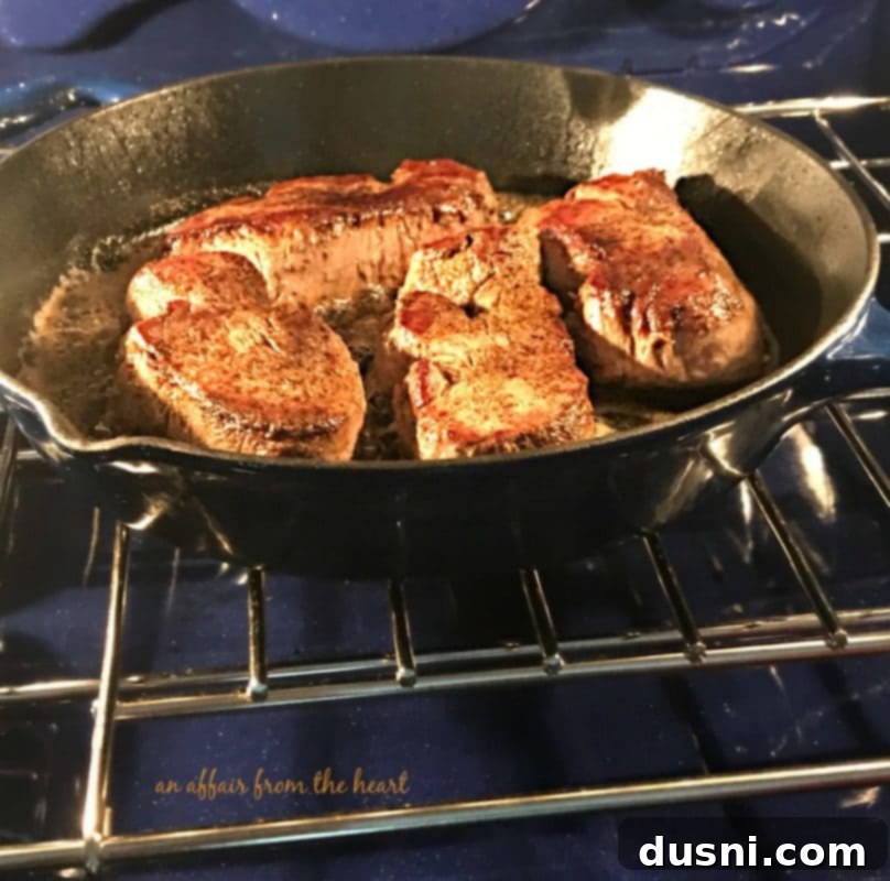 Gourmet Herb Butter Filet Mignon 5 Cast iron skillet with seared Filet Mignon steaks, ready to be transferred to the oven.