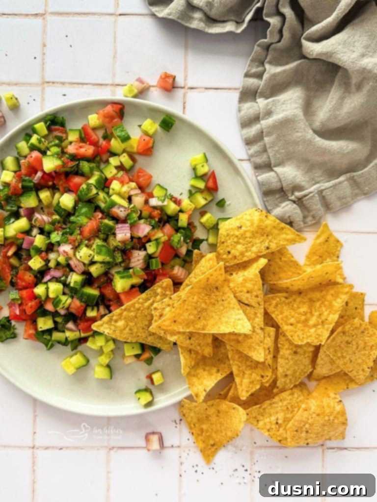 Fresh cucumber salsa in a white bowl, garnished with cilantro.