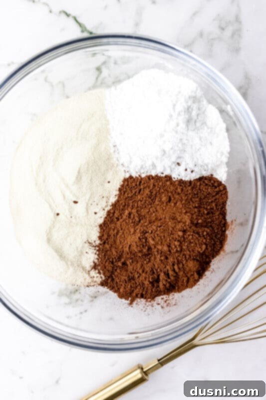 Cozy Homemade Cocoa Blend 5 All three hot cocoa mix ingredients being poured into a large mixing bowl.