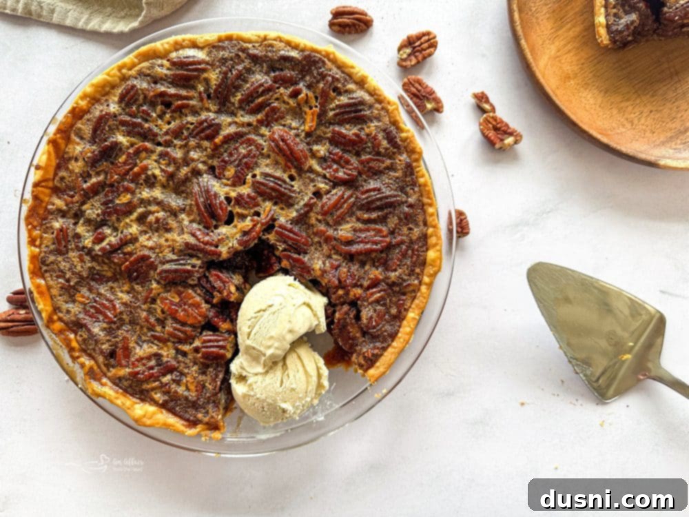 Close-up of a whole pecan pie, showing the pecan topping and golden crust.