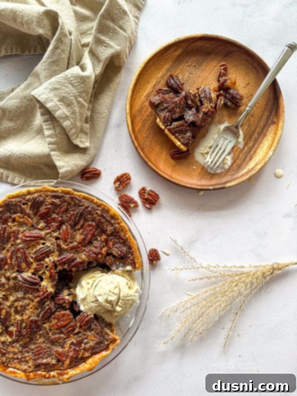 A slice of pecan pie, showing the gooey filling and whole pecans.