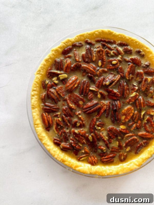 Pecan pie filling poured into a pie crust before baking.