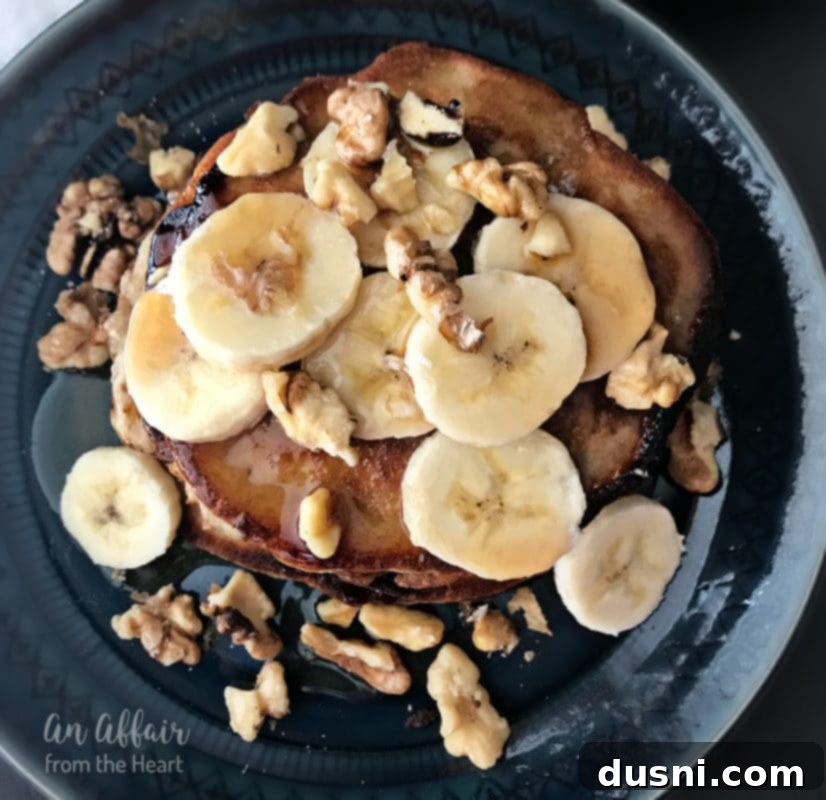 Banana Bread Bliss Stacks 4 A large stack of Banana Bread Pancakes, ready to be served, with a fork poised to take a bite.