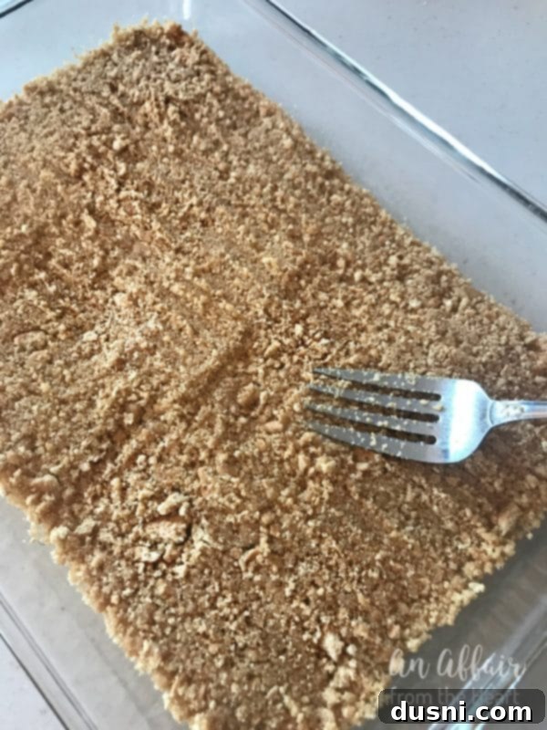 S'mores Brownies prep - pressing the crust into the baking dish