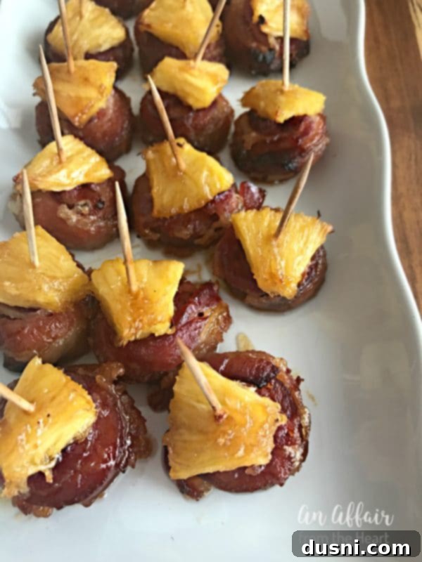Aloha Bacon Wrapped Sausage Poppers 4 Aloha Bacon Wrapped Sausage Bites arranged on a platter